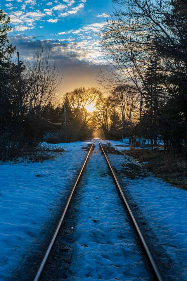 Railroad tracks stretching toward a winter sunset.